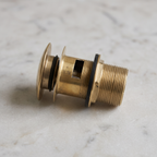 Close-up of the brass drain body showing the overflow slot, rubber seals and threads
