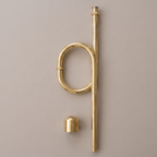 Unlacquered brass floor-mounted S-trap with oval loop and floor cup on a light background