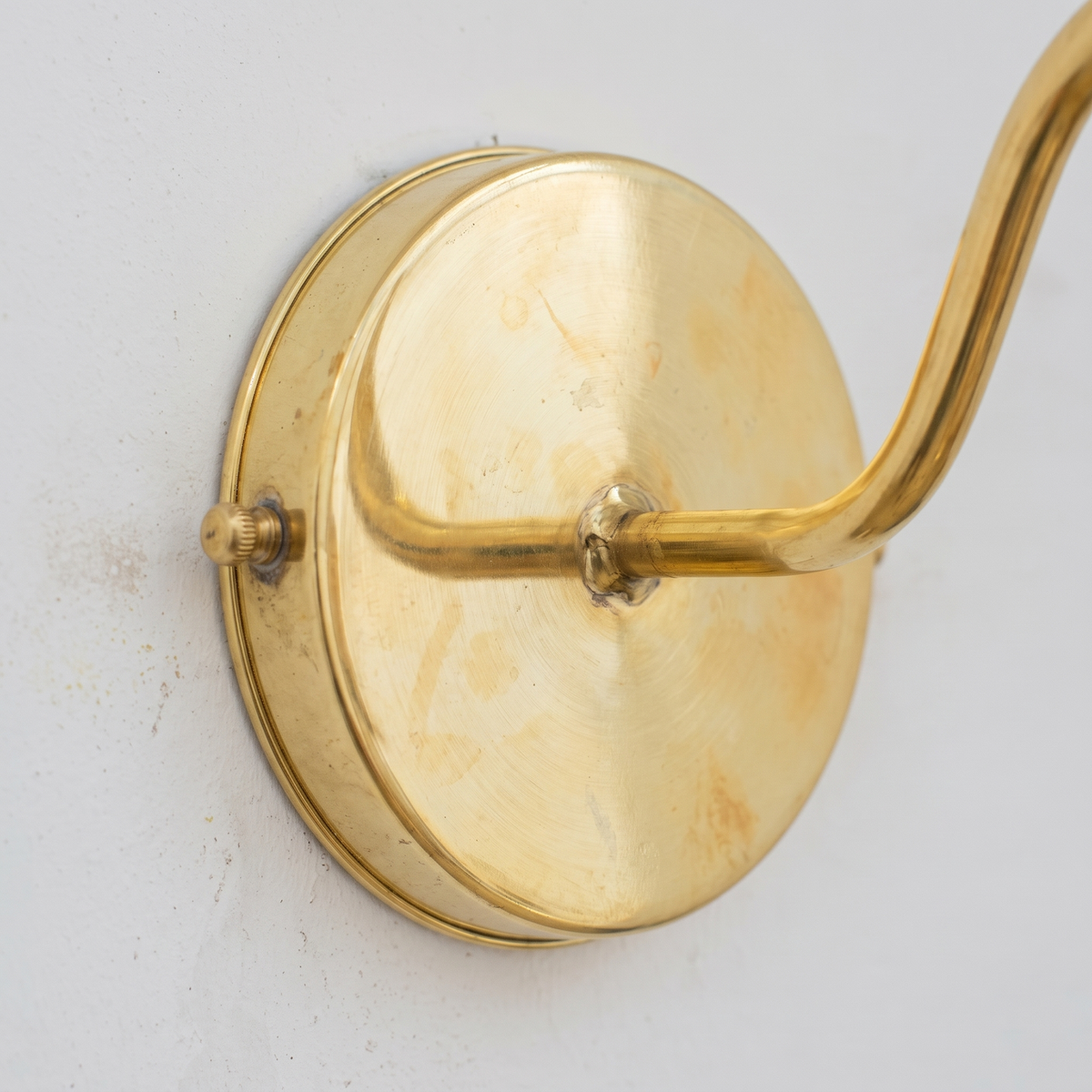 Close-up of the unlacquered brass round backplate and arm