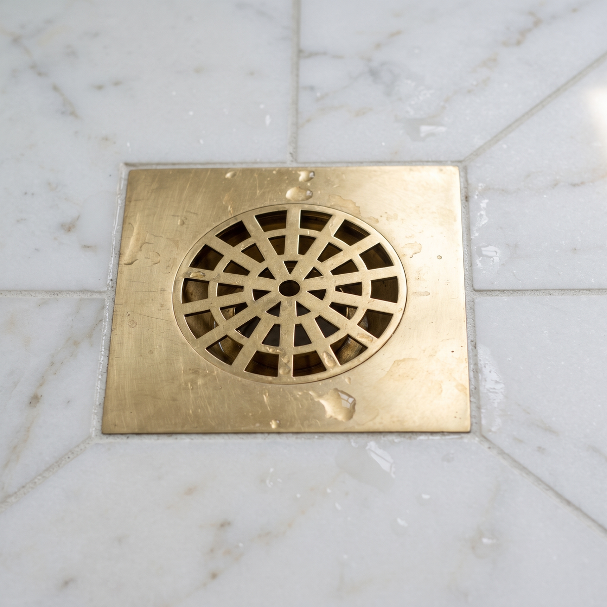 Close view of the brass web pattern grate with water droplets