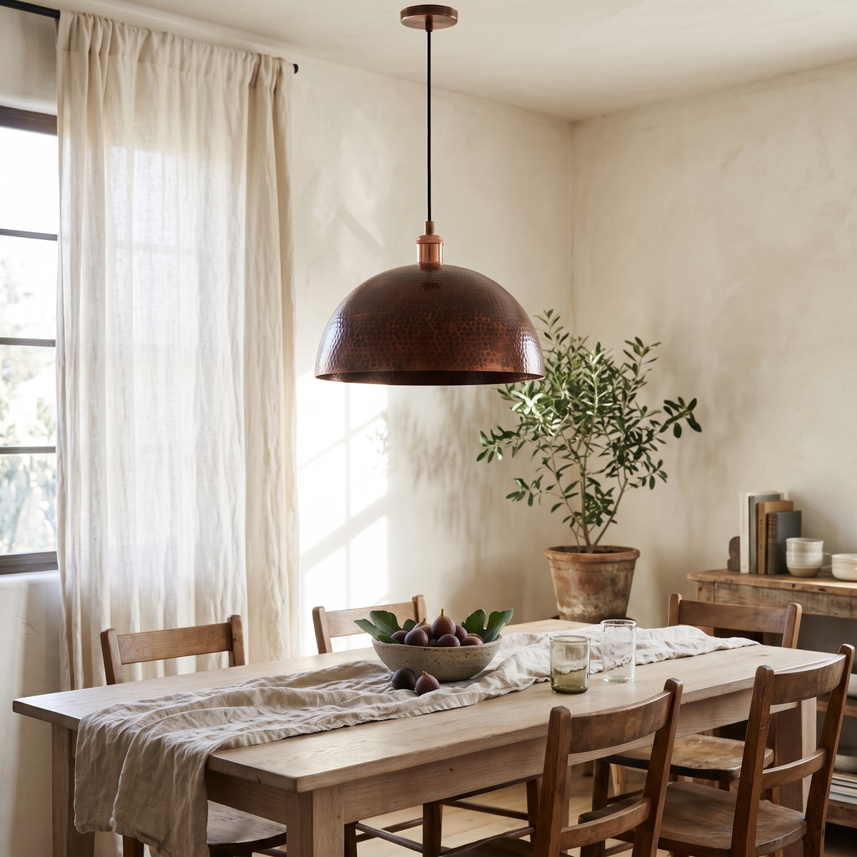 Vintage hammered copper dome pendant over a white oak dining table