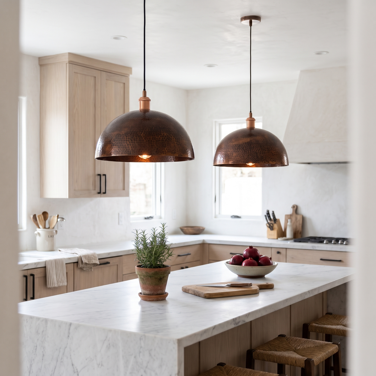 Two vintage hammered copper dome pendant lights over a white marble kitchen island